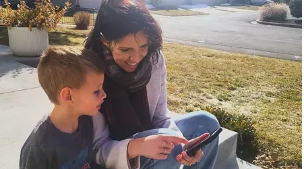 Julie with her son looking at something on her phone